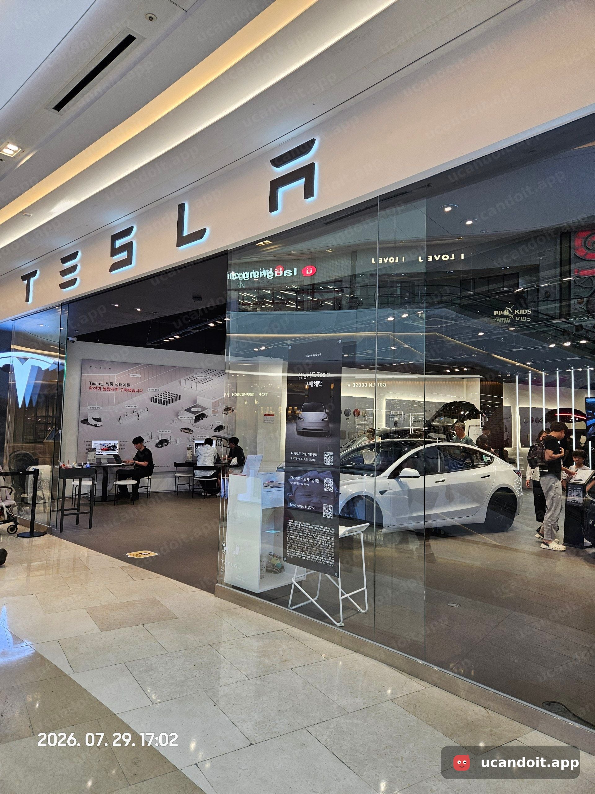 테슬라 스타필드 하남점 매장 전경 – 흰색 Model 3 전시차 및 상담 직원
